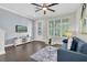 Inviting living room with dark wood floors, a modern blue sofa, and plenty of natural light from the windows at 106 Cutlass Way, Oldsmar, FL 34677