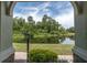 Scenic view of a tranquil pond framed by an arched doorway with lush greenery and a serene atmosphere at 106 Cutlass Way, Oldsmar, FL 34677