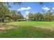Large grassy backyard with a covered shelter, and scattered trees at 11029 Clay Pit Rd, Tampa, FL 33610