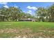 Large, grassy backyard with a covered shelter and view of the single-story home at 11029 Clay Pit Rd, Tampa, FL 33610