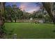 Exterior rear view of home with a porch, surrounded by trees and a grassy lawn at 11029 Clay Pit Rd, Tampa, FL 33610