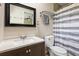 Neutral bathroom with a large mirror, a toilet, and a sink with cabinet at 11029 Clay Pit Rd, Tampa, FL 33610