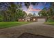 Charming brick home features a brick driveway, an attached two-car garage, and a well-maintained lawn with mature trees at 11029 Clay Pit Rd, Tampa, FL 33610