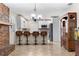 Spacious living area featuring a brick fireplace, open to an updated kitchen with bar seating at 11029 Clay Pit Rd, Tampa, FL 33610