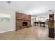 Open concept living space with a brick fireplace, tiled floors, and a seamlessly integrated, modern kitchen at 11029 Clay Pit Rd, Tampa, FL 33610