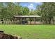 Open-sided storage structure, or outbuilding, on a large grassy lot at 11029 Clay Pit Rd, Tampa, FL 33610