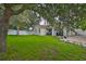 Well-maintained backyard featuring grass, trees, and a white privacy fence at 11415 Bright Star Ln, Riverview, FL 33569