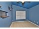 A blue bedroom features a tile floor, a built-in shelf, and a window bringing in natural light at 11415 Bright Star Ln, Riverview, FL 33569