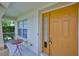 Inviting front porch with seating area and a bright yellow front door with glass panels at 11415 Bright Star Ln, Riverview, FL 33569