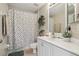 Bright bathroom with a decorative shower curtain, white vanity, and neutral wall color at 11708 Crest Creek Dr, Riverview, FL 33569