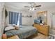 Bedroom featuring a ceiling fan, dresser, and a large window with soft, natural lighting at 11708 Crest Creek Dr, Riverview, FL 33569
