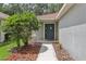 Inviting front entrance with decorative shrubbery and a sidewalk leading to the blue front door at 11708 Crest Creek Dr, Riverview, FL 33569