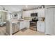 Well-lit kitchen featuring stainless steel appliances, white cabinets, and an open layout to the living room at 11708 Crest Creek Dr, Riverview, FL 33569