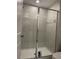 Bathroom shower featuring glass doors and tiled walls at 11901 Castine St, New Port Richey, FL 34654