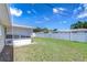 The fenced backyard has green grass and an enclosed patio at 12033 82Nd Ave, Seminole, FL 33772