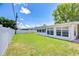 Expansive backyard featuring lush green grass, a fenced perimeter, and views of the home's back exterior at 12033 82Nd Ave, Seminole, FL 33772