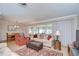 Open-concept living and dining area with a comfortable recliner, sofas, and natural light at 12033 82Nd Ave, Seminole, FL 33772