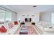 Open living room design with neutral tones, two sofas, a leather ottoman, and a mounted television at 12033 82Nd Ave, Seminole, FL 33772