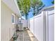 A view of the side yard with an AC unit and a white fence for privacy at 12033 82Nd Ave, Seminole, FL 33772