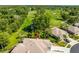 Aerial view showing the house, golf course, mature trees, and lush landscaping at 12134 Tournament View Ave, New Port Richey, FL 34654