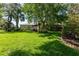 Expansive backyard with lush green lawn, mature trees, and patio area at 12134 Tournament View Ave, New Port Richey, FL 34654