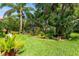 Lush backyard with mature trees, manicured lawn, and various plants at 12134 Tournament View Ave, New Port Richey, FL 34654