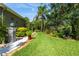 Lush backyard with well-manicured lawn, mature landscaping, and decorative elements at 12134 Tournament View Ave, New Port Richey, FL 34654
