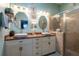 Well-lit bathroom featuring double sinks, vanity, and a glass-enclosed shower at 12134 Tournament View Ave, New Port Richey, FL 34654