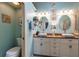 Stylish bathroom featuring double sinks, white cabinetry, and artistic accents at 12134 Tournament View Ave, New Port Richey, FL 34654