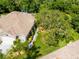 Aerial view of a well-kept home with a meticulously landscaped yard, lush trees, and a serene atmosphere at 12134 Tournament View Ave, New Port Richey, FL 34654