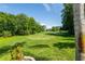 Picturesque view of a lush green golf course, showcasing manicured lawns and mature trees against a clear blue sky at 12134 Tournament View Ave, New Port Richey, FL 34654