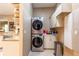 Modern laundry room featuring a stacked washer and dryer unit with cabinets above and tiled flooring at 12134 Tournament View Ave, New Port Richey, FL 34654