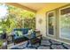 Screened patio featuring a comfortable couch, decorative pillows, and lush greenery for a relaxing outdoor space at 12134 Tournament View Ave, New Port Richey, FL 34654