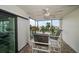 Condo balcony seating area featuring tile floors with views of the surrounding pool and beach area at 1230 Gulf Blvd # 304, Clearwater, FL 33767