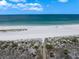 Aerial view of a beautiful white sand beach and calm, turquoise waters at 1230 Gulf Blvd # 304, Clearwater, FL 33767
