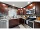 Well-equipped kitchen with stainless steel appliances and dark wood cabinets at 1230 Gulf Blvd # 304, Clearwater, FL 33767