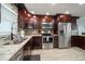 Modern kitchen with stainless steel appliances, granite countertops, and dark cabinetry at 1230 Gulf Blvd # 304, Clearwater, FL 33767