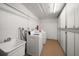 On-site laundry room with multiple washing machines, sink, and storage at 1230 Gulf Blvd # 304, Clearwater, FL 33767