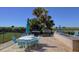 Outdoor kitchen and dining area with built-in grill, granite countertops, and umbrella-covered table at 1230 Gulf Blvd # 304, Clearwater, FL 33767