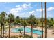 View of a swimming pool with tropical landscaping with views of the beach in the background at 1230 Gulf Blvd # 304, Clearwater, FL 33767