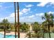 View of the swimming pool and walkway to the beach surrounded by palm trees and tropical foliage at 1230 Gulf Blvd # 304, Clearwater, FL 33767