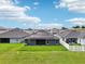 Backyard view of the house featuring solar panels, a screened lanai and fenced area at 12937 Ogden Glade Rd, Dade City, FL 33525