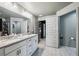 Spacious bathroom featuring double vanity, granite countertops, modern lighting, and gray-tone flooring at 12937 Ogden Glade Rd, Dade City, FL 33525