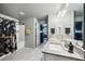 Bright bathroom featuring double sinks, granite countertops, decorative lighting, and a bathtub with shower at 12937 Ogden Glade Rd, Dade City, FL 33525