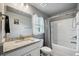 Well-lit bathroom with gray walls features a granite vanity, framed mirror and shower with curtain at 12937 Ogden Glade Rd, Dade City, FL 33525
