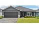 Charming one-story home with a paved driveway, manicured lawn, and a two-car garage in a modern color scheme at 12937 Ogden Glade Rd, Dade City, FL 33525