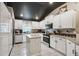 Well-lit kitchen featuring white cabinets, granite countertops, and stainless steel appliances at 12937 Ogden Glade Rd, Dade City, FL 33525