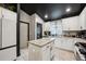 Modern eat-in kitchen with island, black ceiling, white cabinets, granite counters, and stainless appliances at 12937 Ogden Glade Rd, Dade City, FL 33525