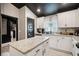 Bright kitchen featuring granite countertops, modern cabinets, and a contrasting black door with a breakfast bar at 12937 Ogden Glade Rd, Dade City, FL 33525