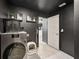 Modern laundry room with black walls boasts a front loading washer/dryer and decor at 12937 Ogden Glade Rd, Dade City, FL 33525